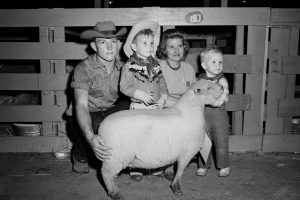 A young family poses with a Southdown sheep