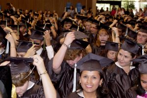 New graduates move their tassels from left to right