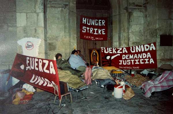 A photo from the 1990s shows protesters gathered in front of a building with signs declaring they are part of a hunger strike.