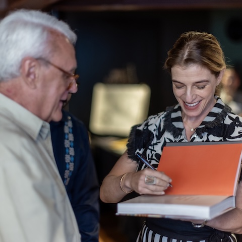 Pati Jinich signs a copy of her book
