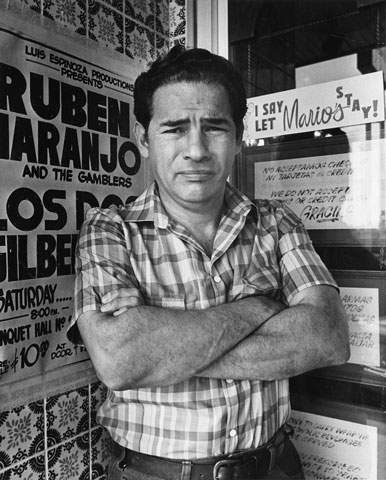 A black and white image of Mario Cantu standing outside of his restaurant in 1985.