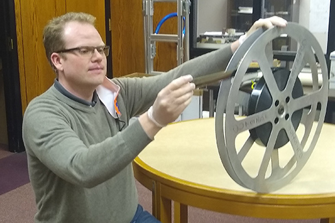 Barrett Codieck examines one of the old reels from the collection.