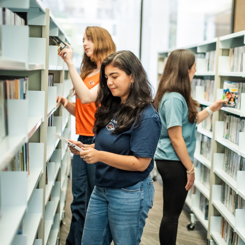 UTSA students browsing the library stacks