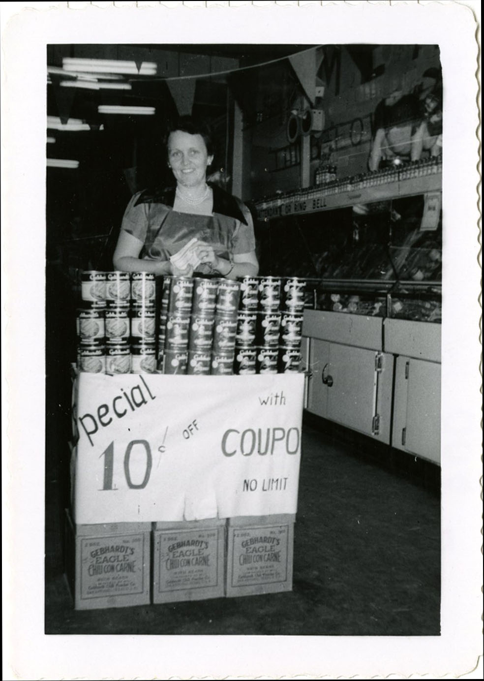 Female standing beside coupon sign and store display